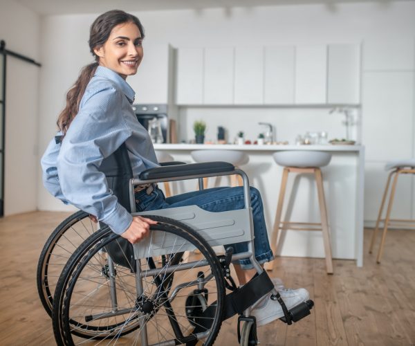 A smiling young woman sitting in a wheelchair